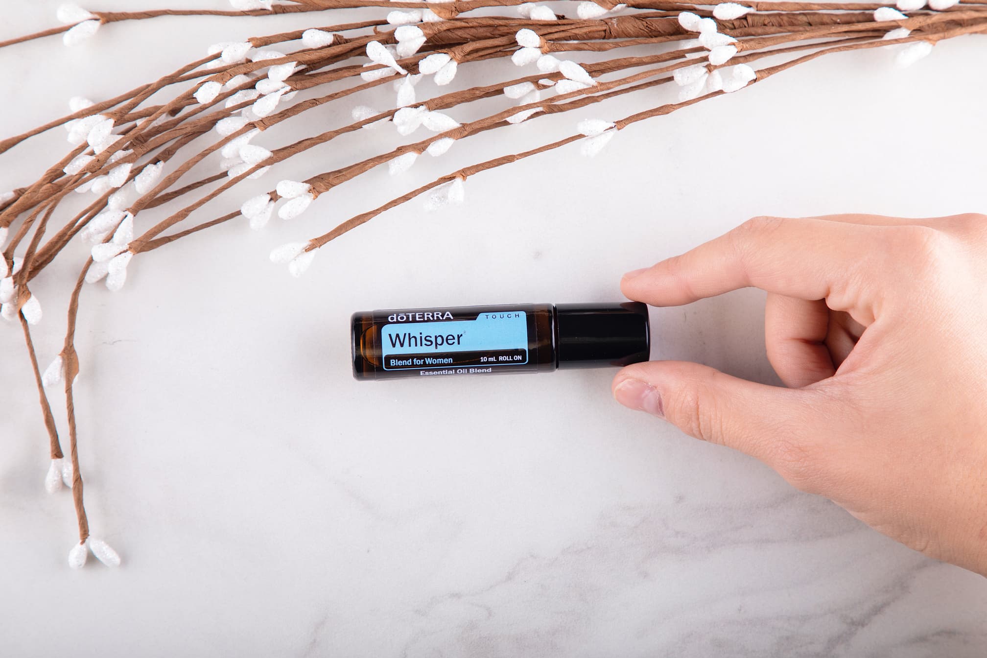 Рука держит небольшой роллер doTERRA